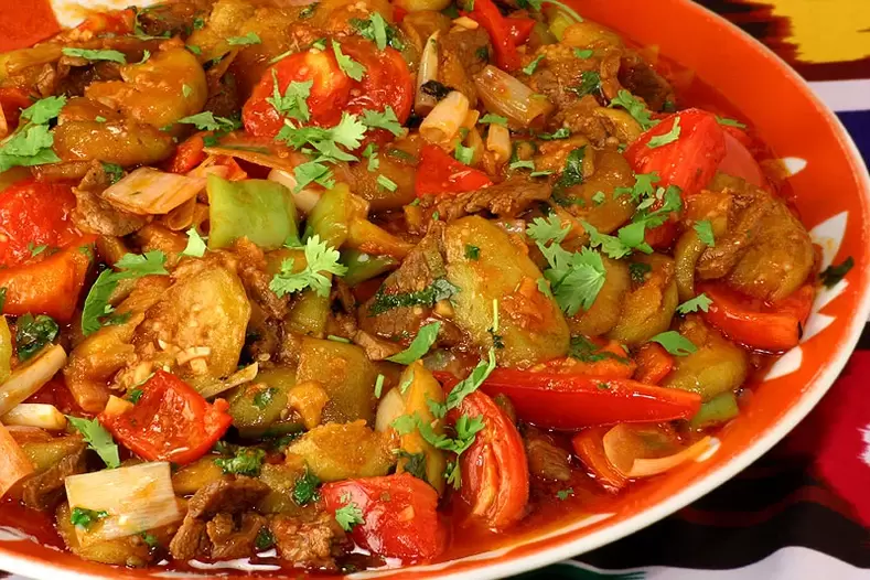 Tomates, pimientos morrones y berenjenas guisados un plato del día de las verduras de la dieta de los 6 pétalos